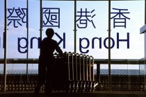 Persona con carritos de equipaje en el aeropuerto - foto de stock