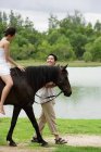 Femme chevauchant à cheval — Photo de stock