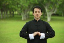 Человек в кимоно практикует медитацию — стоковое фото