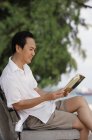 Людина на пляжі читає книгу — стокове фото