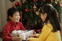 Boy and girl sitting with presents — Stock Photo