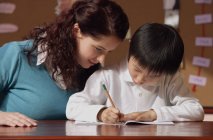Teacher helping young student — Stock Photo