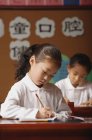 Écolières écriture en classe — Photo de stock