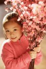 Asian girl with cherry blossom branches — Stock Photo