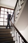 Businessman walking down the stairs — Stock Photo