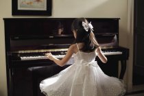 Giovane ragazza che suona il pianoforte — Foto stock