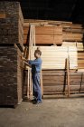 Homem a trabalhar em madeira serrada — Fotografia de Stock