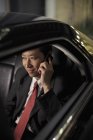 Homme d'affaires assis dans la voiture et parlant au téléphone — Photo de stock