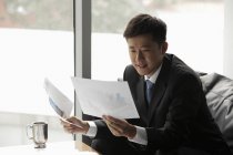 Businessman in suit looking at papers — Stock Photo