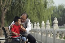 Abuelo dando un helado a su nieto - foto de stock