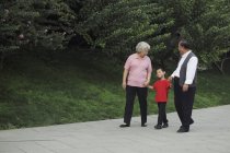Літня пара гуляє з онуком — стокове фото