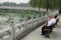 Старшая пара сидит на скамейке в парке — стоковое фото