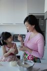 Mãe ensinando filha cozinhar — Fotografia de Stock