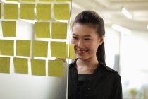 Woman looking at sticky notes — Stock Photo