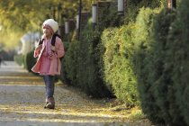 Молодая азиатская девушка идет по тротуару — стоковое фото