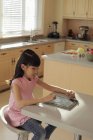 Asian girl plays on digital tablet — Stock Photo