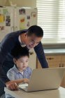 Père et fils travaillant sur ordinateur portable — Photo de stock