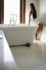 Femme assise sur la baignoire — Photo de stock