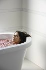 Donna che posa nella vasca da bagno — Foto stock