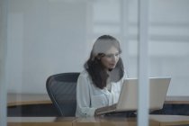 Femme d'affaires utilisant un ordinateur portable dans le bureau — Photo de stock