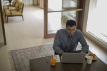 Businessman at home using laptop — Stock Photo