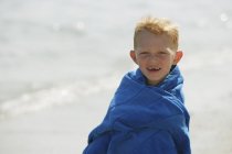 Хлопчик загорнутий в синій рушник — стокове фото