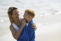 Madre e hijo en la playa - foto de stock