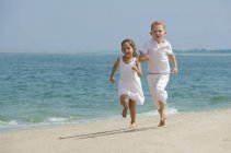 Счастливые дети бегают по пляжу — стоковое фото