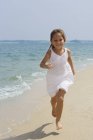 Little girl running on beach — Stock Photo