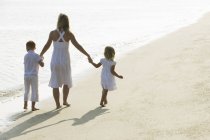 Femme avec enfants sur la plage — Photo de stock
