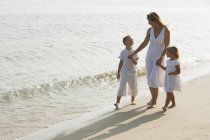 Femme avec enfants sur la plage — Photo de stock