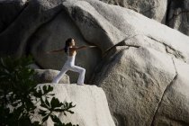 Жінка робить йогу на скелі — стокове фото