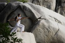 Пара робить йогу на скелі — стокове фото