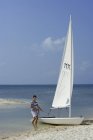 Людина з вітрильним човном на пляжі — стокове фото