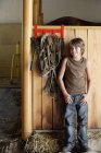Хлопчик в стайні поруч з конем — стокове фото