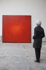 Frau schaut auf rotes Quadrat Bild — Stockfoto