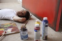 Мужчина-художник лежит на земле — стоковое фото