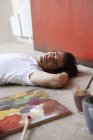 Чоловік художник лежить на землі — стокове фото