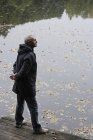 Senior man overlooking pond — Stock Photo