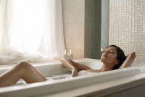 Женщина, лежащая в ванной — стоковое фото