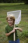 Маленький хлопчик тримає мережу метеликів — стокове фото