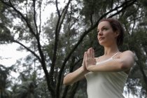 Donna che fa esercizi di yoga sotto gli alberi — Foto stock