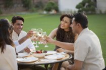 Friends drinking wine at table — Stock Photo