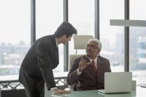 Businessman talking with younger man — Stock Photo