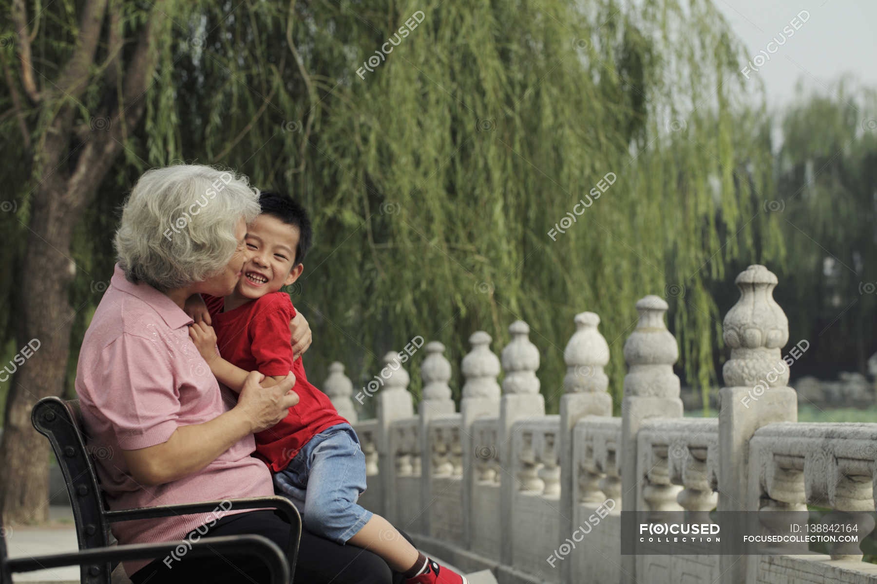 Grandmother Hugging And Kissing Grandson — Generation Gap Outdoor