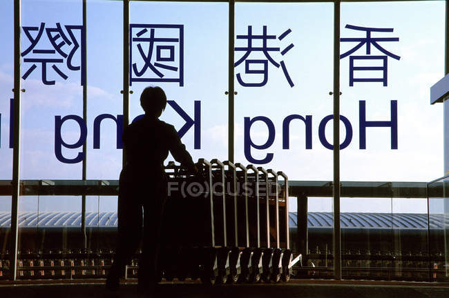 Человек с багажными тележками в аэропорту — стоковое фото