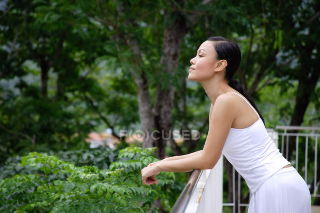 Woman leaning on railing — Stock Photo