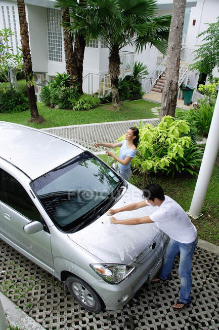 Paar wäscht Auto — Stockfoto
