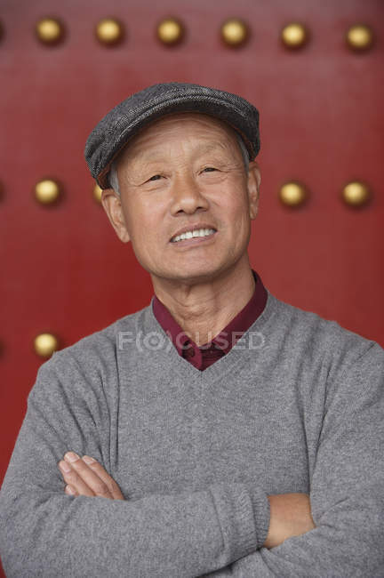 Old man crosses his arms — Stock Photo