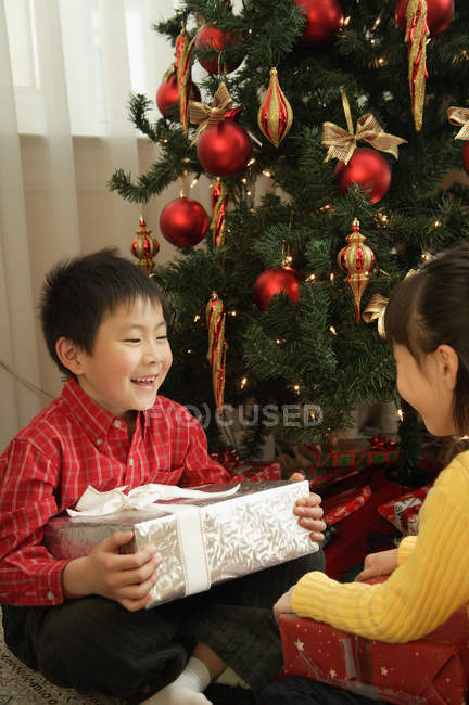 Хлопчик і дівчинка сидять з подарунками — стокове фото